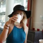 Blonde teen with black hat and neckband drinking juice