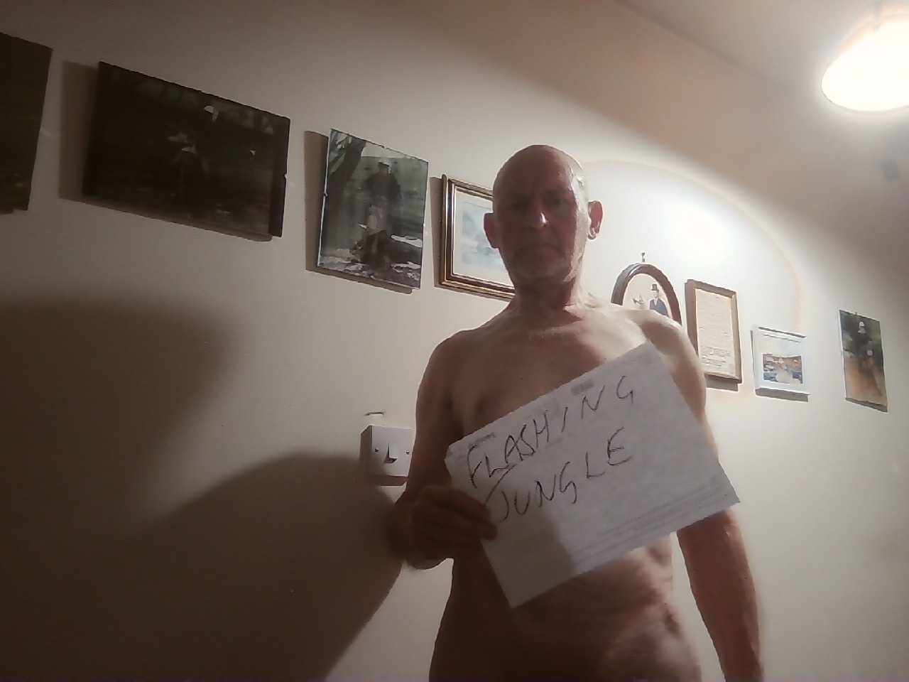 flashing jungle sex - Indoor Flashing Encounter: Amateur Exposes in the Hallway A man stands in a dimly lit hallway, holding a paper that reads 'FLASHING JUNGLE' against his chest, creating a charged atmosphere of anticipation and e... - Real Amateurs