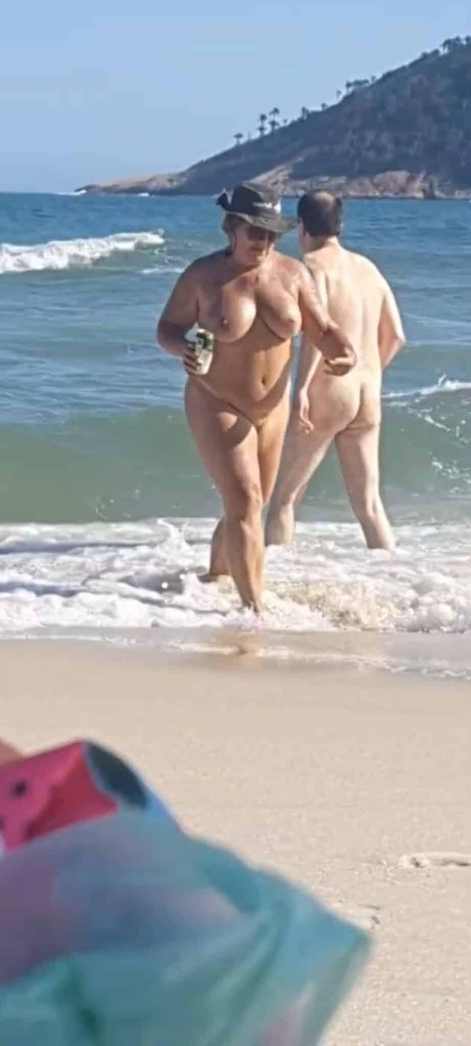 nud big boobs picr - Can a MILF Get Away with Nudity on a Public Beach? A nude MILF and man stand confidently in shallow ocean waves on a public beach, fully exposed and unapologetic in their nudity, challenging societal norms. - Ass Flash Pics
