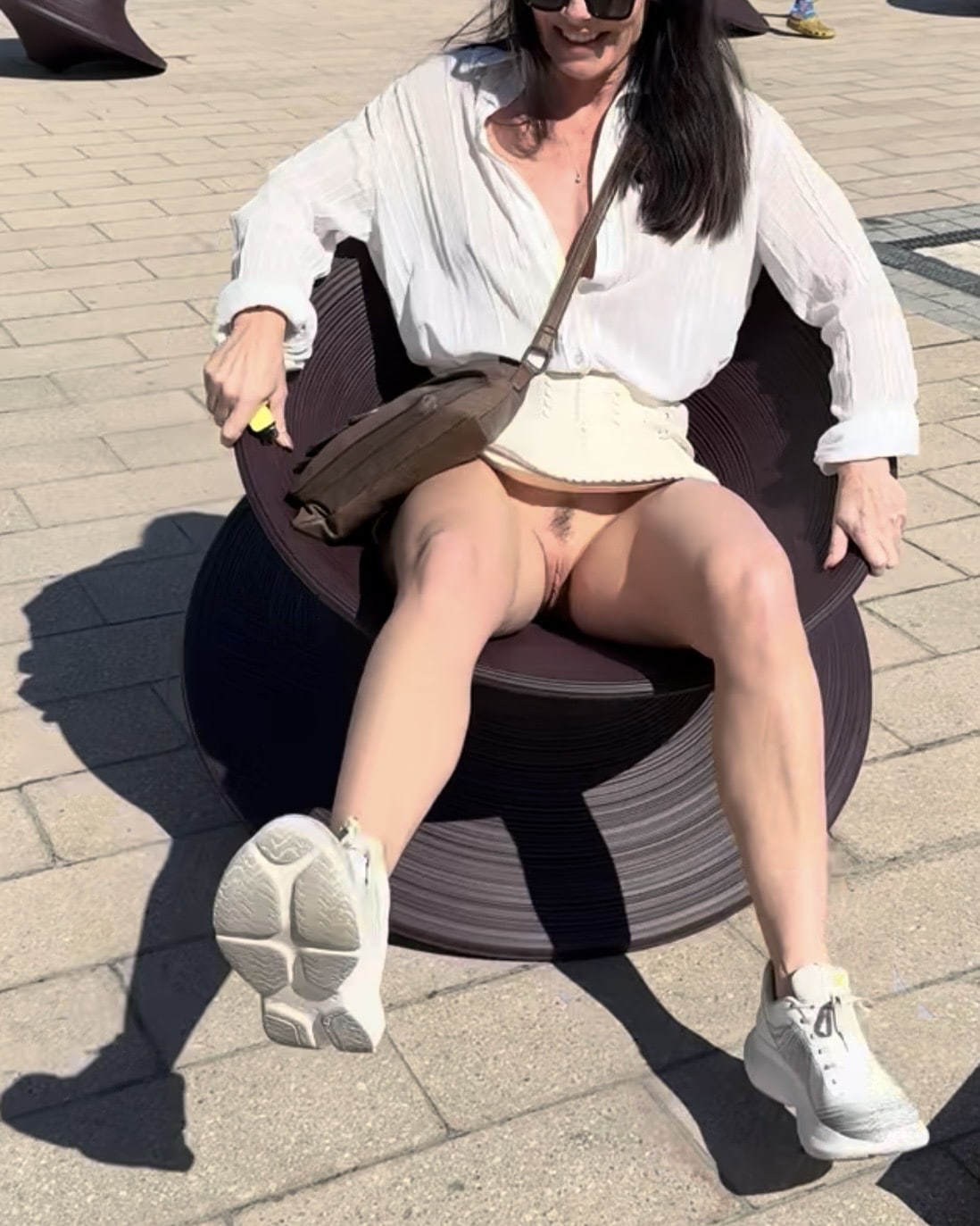 cardi b nude pics waptrick com - Public Bench Exposure: Natural Bush on Display A woman sits on a public bench, partially nude with her natural bush exposed, wearing a mini skirt and white sneakers, smiling playfully. - Public Flashing Pics