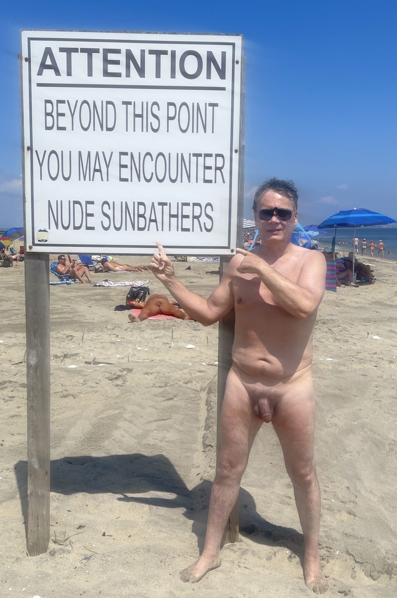 twitch flashing tits leaked - What Does a Nude Man Pointing at a Sign on a Beach Say About Public Nudity? A nude man on a beach points at a sign warning of nude sunbathers, highlighting the power dynamic of public nudity. - Dick Flash Pics