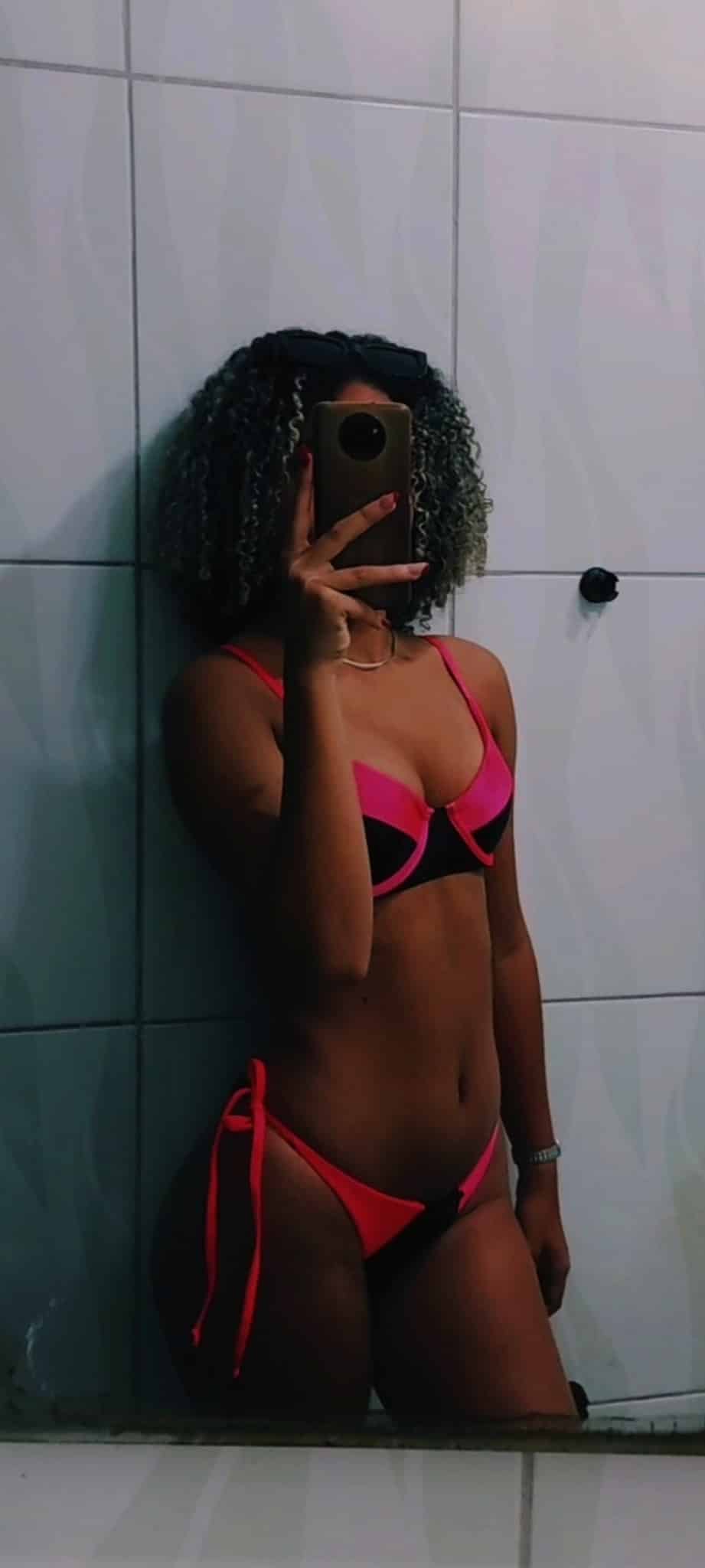 Ass Flash Pics: Lívia Vitória 5: A Curvy Black Woman’s Confident Mirror Selfie A curvy Black woman poses confidently in a bathroom mirror selfie, showcasing her figure in a two-tone bikini, with a focus on her ass and cleavage.